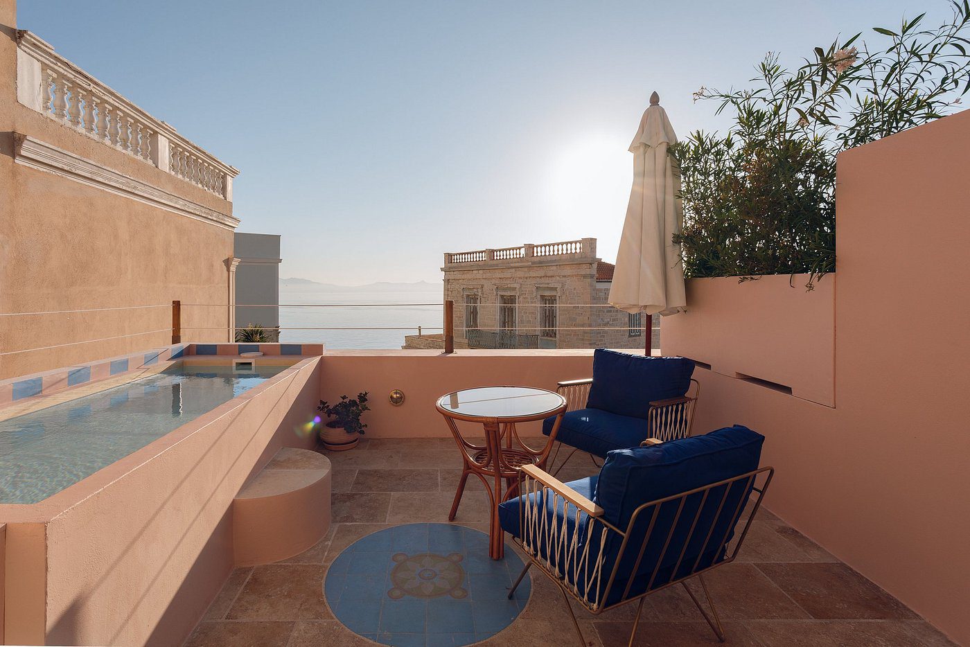 Cozy rooftop terrace with seating and sea view at sunset.
