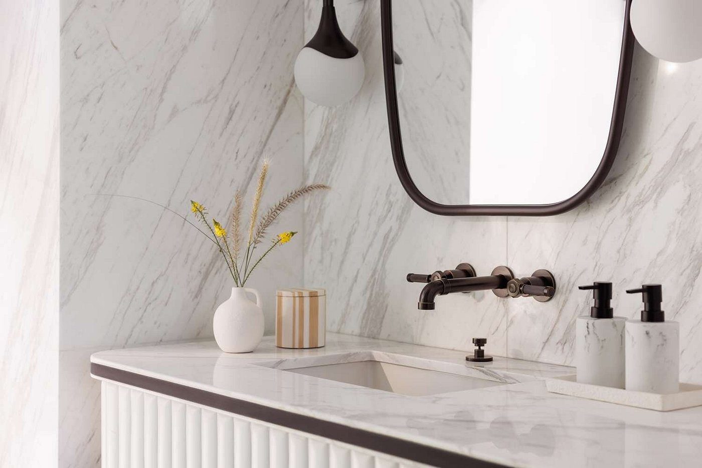 Elegant bathroom vanity with marble walls and minimalist decor.