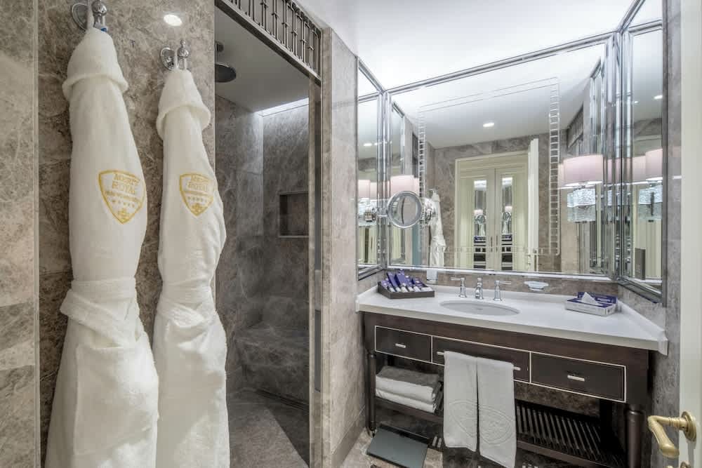 Modern bathroom with glass shower and double sinks.