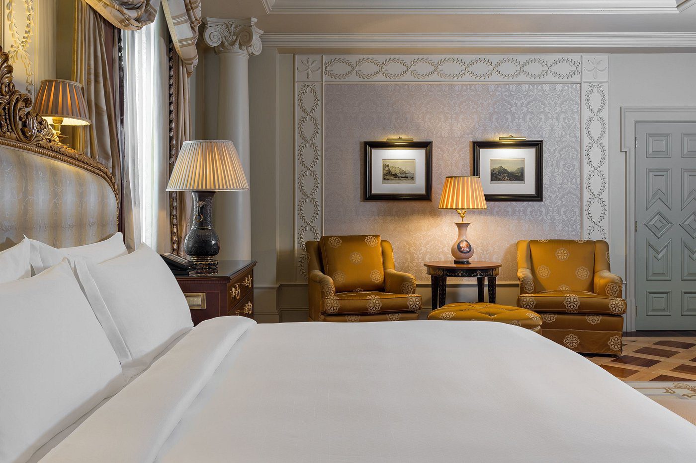 Elegant hotel room with cozy seating and warm lighting.