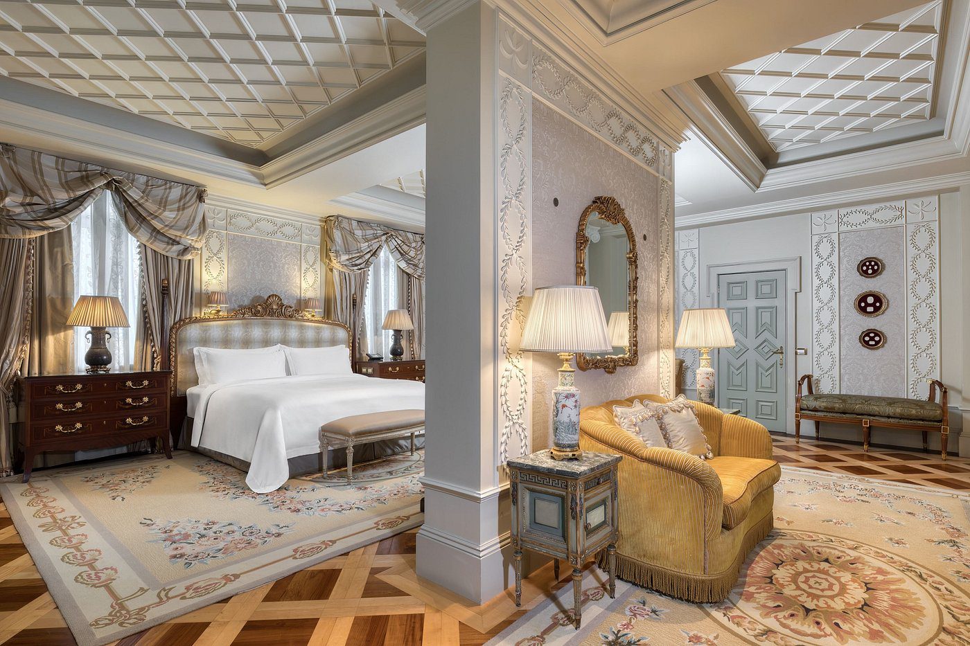 Elegant bedroom with classic decor and cozy seating area.