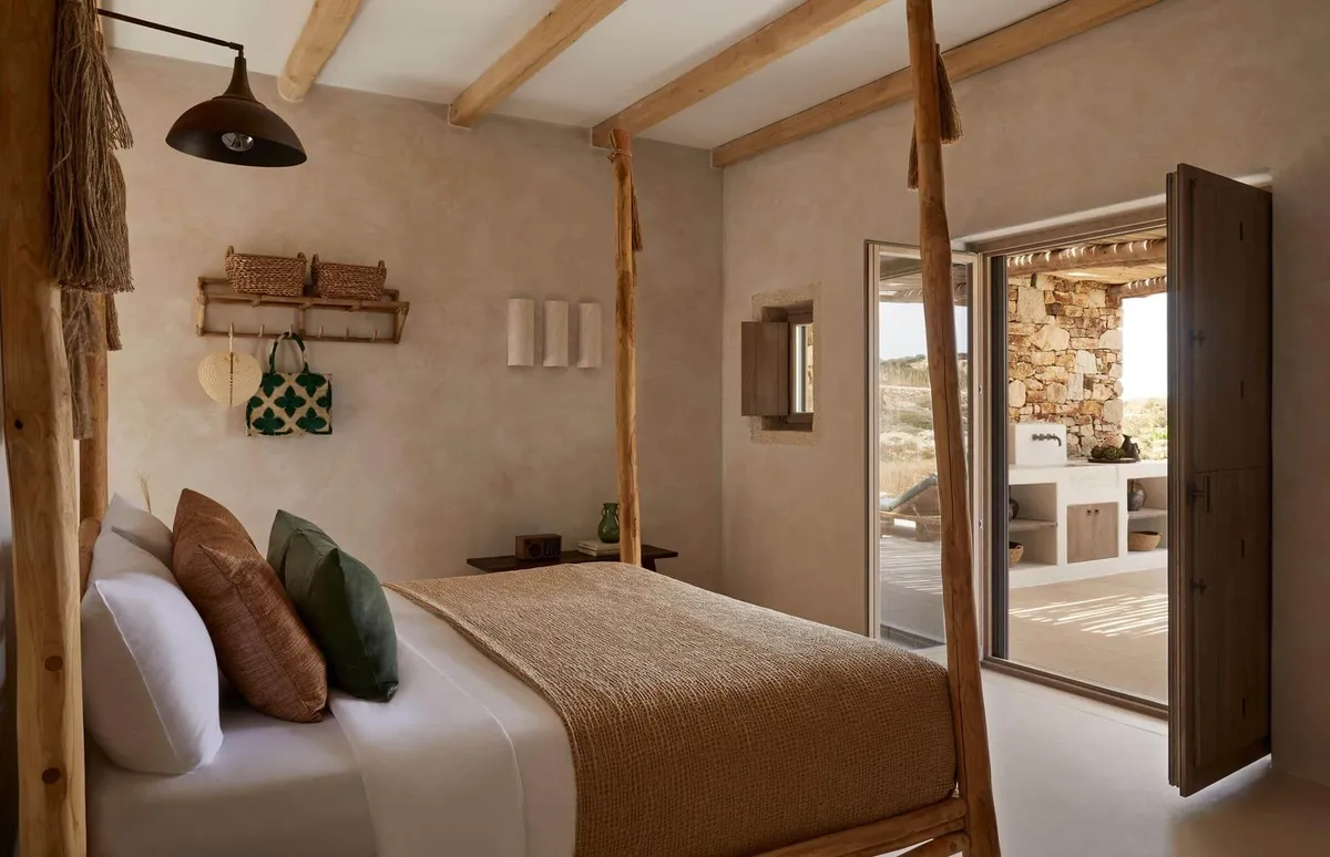 Cozy bedroom with wooden beams and warm lighting.