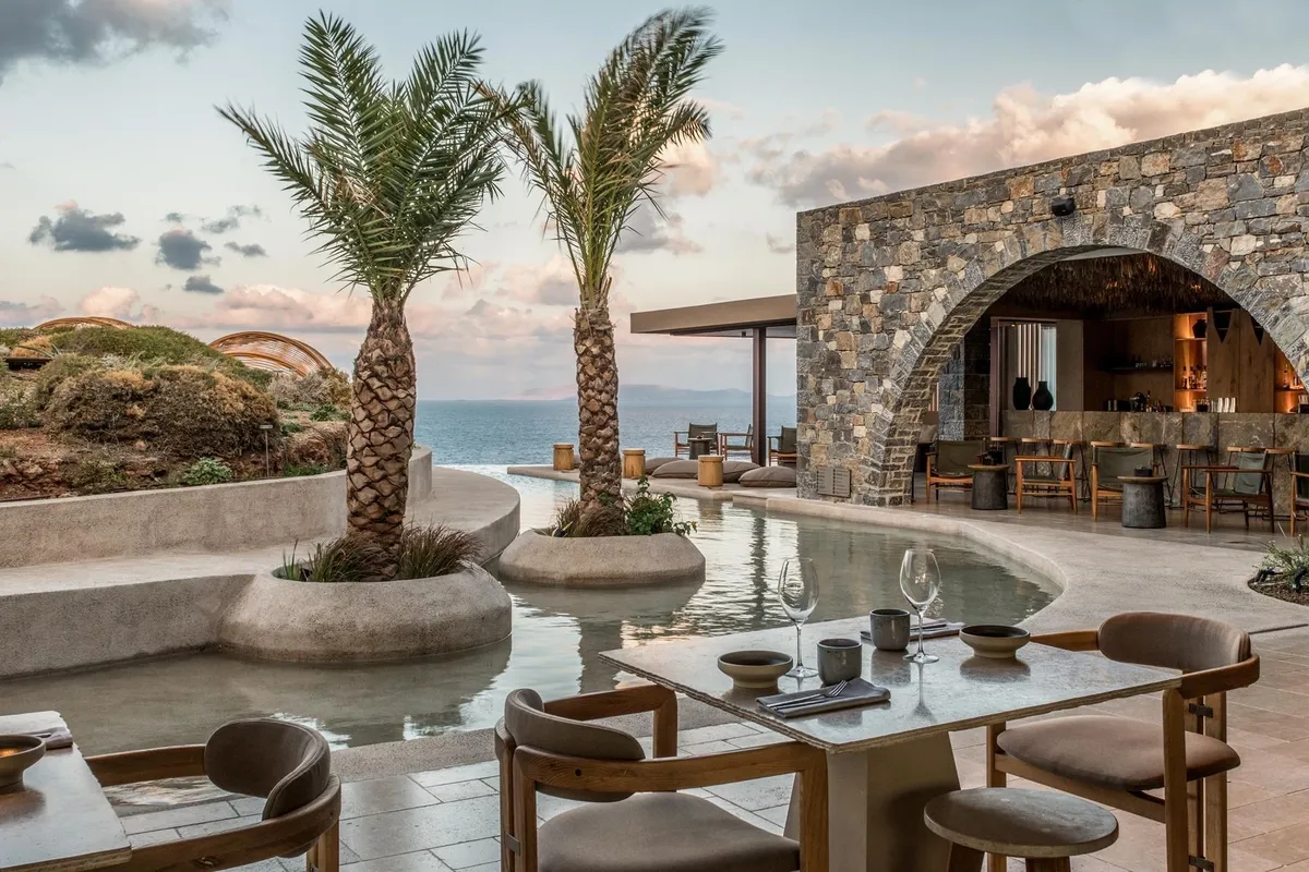 Elegant outdoor dining with ocean view and palm trees.