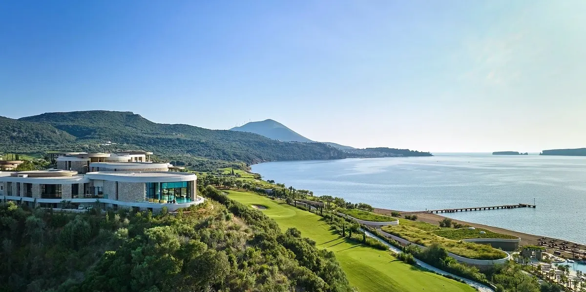 Scenic coastal view with lush greenery and mountains.