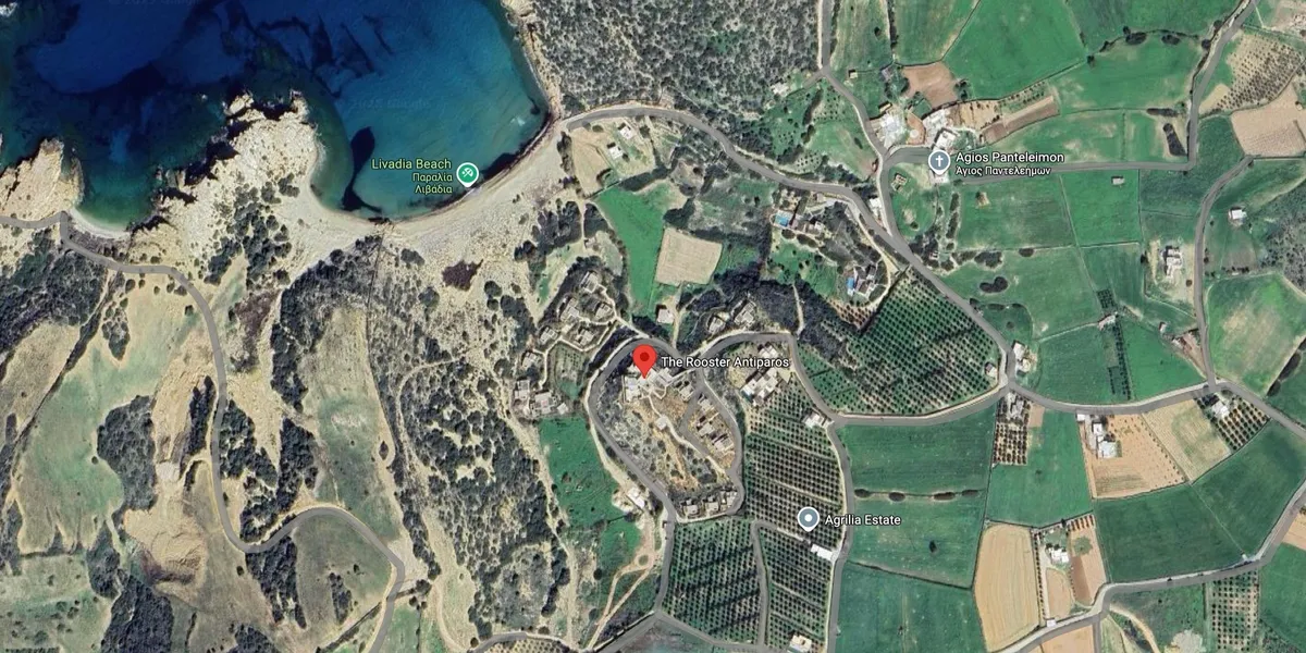 Aerial view of a coastal town with fields and a beach.
