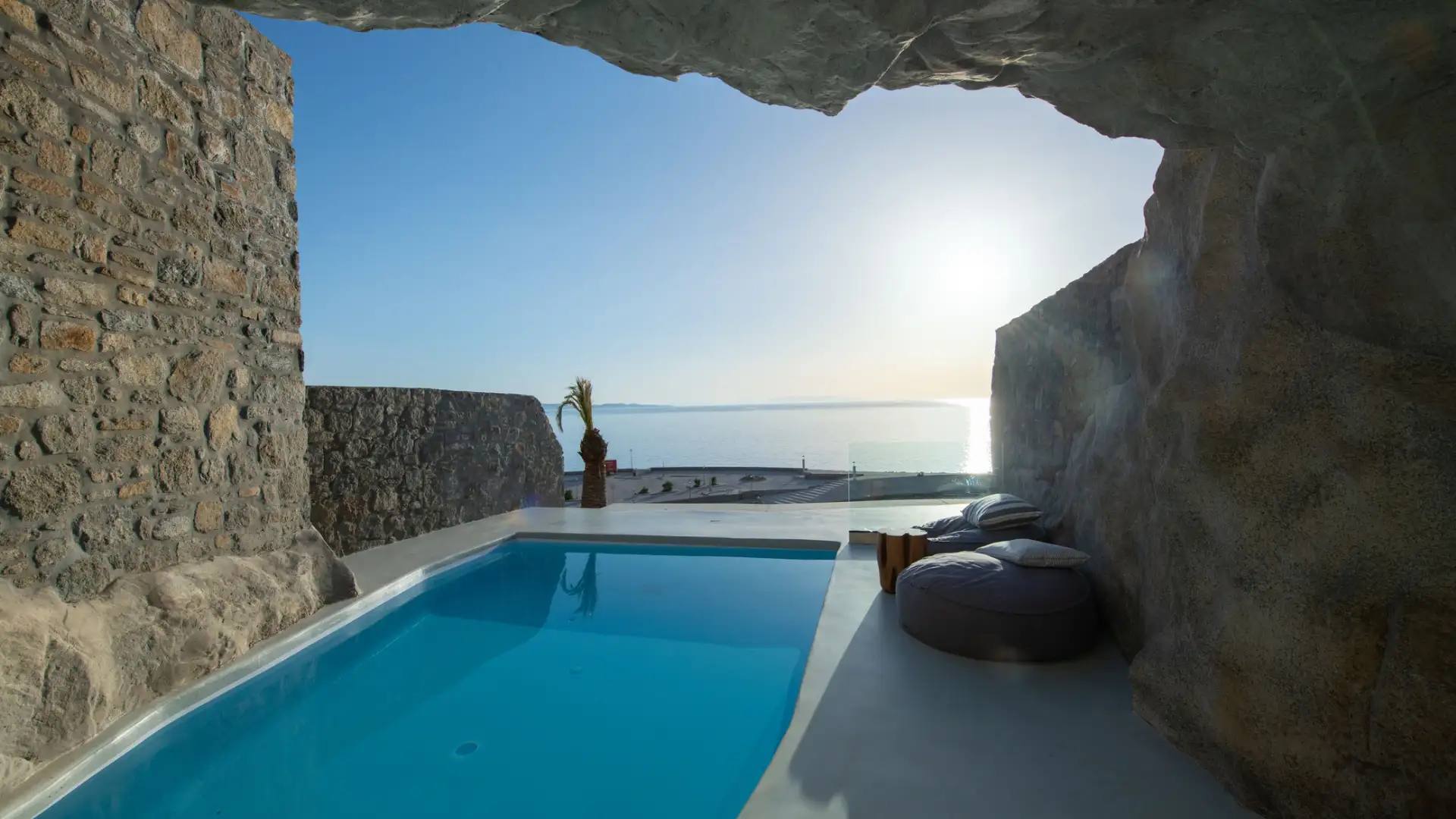 A serene poolside view overlooking the ocean at sunset.