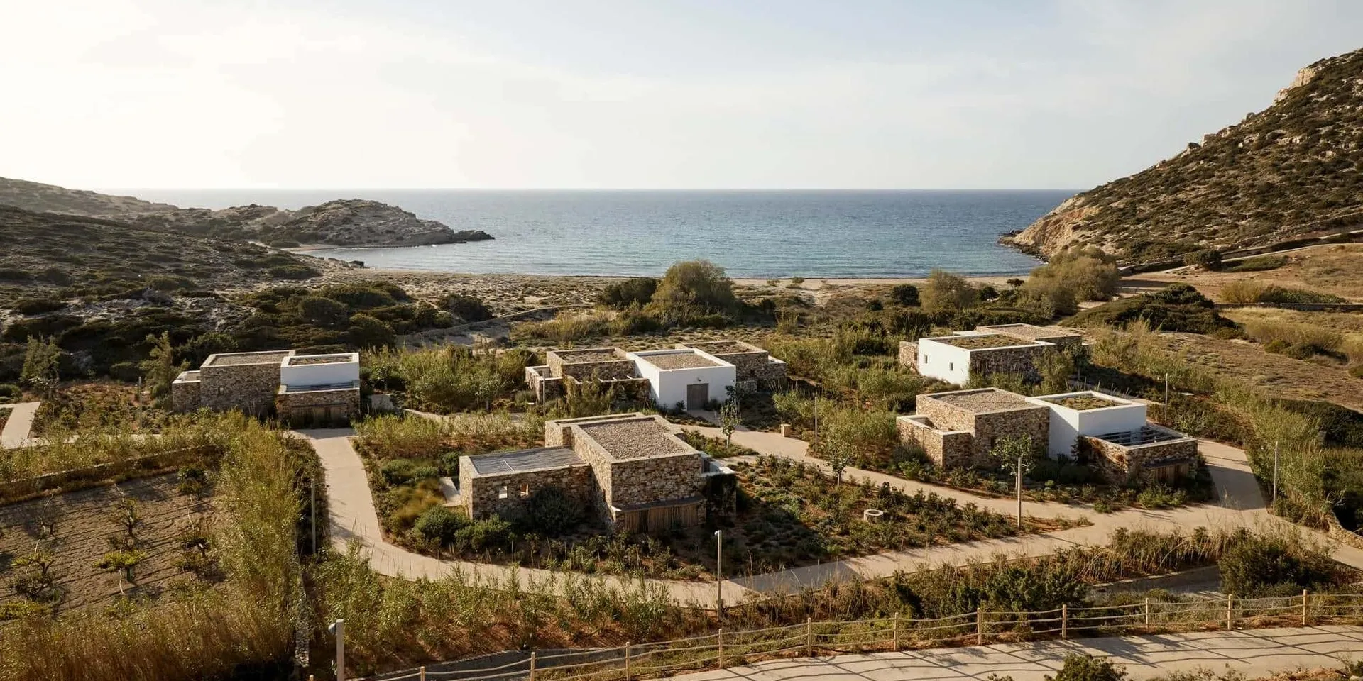 Small houses near a calm coastal area with clear skies.