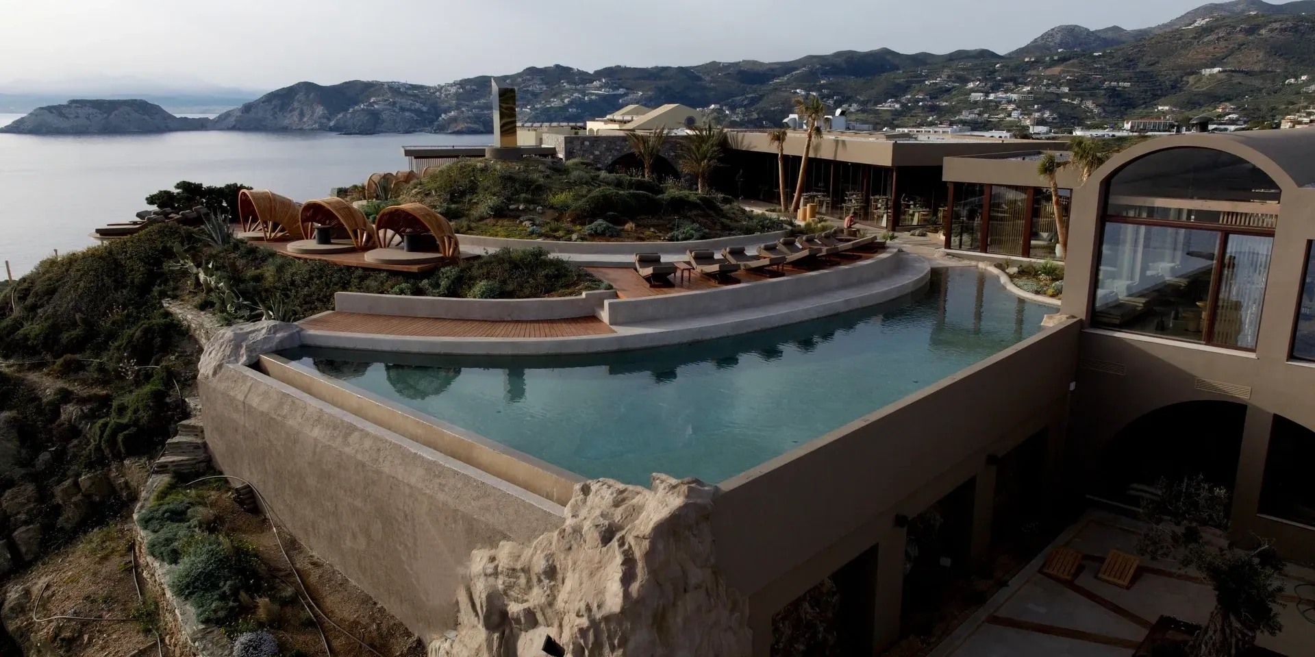 Luxury infinity pool overlooking a scenic coastal landscape at sunset.