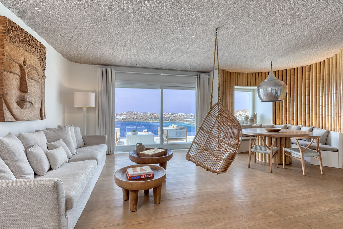 Bright modern living room with ocean view and hanging chair.