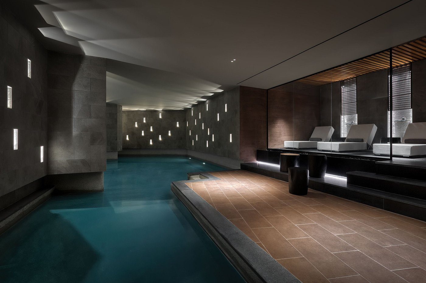 Modern indoor pool with ambient lighting and sleek design.