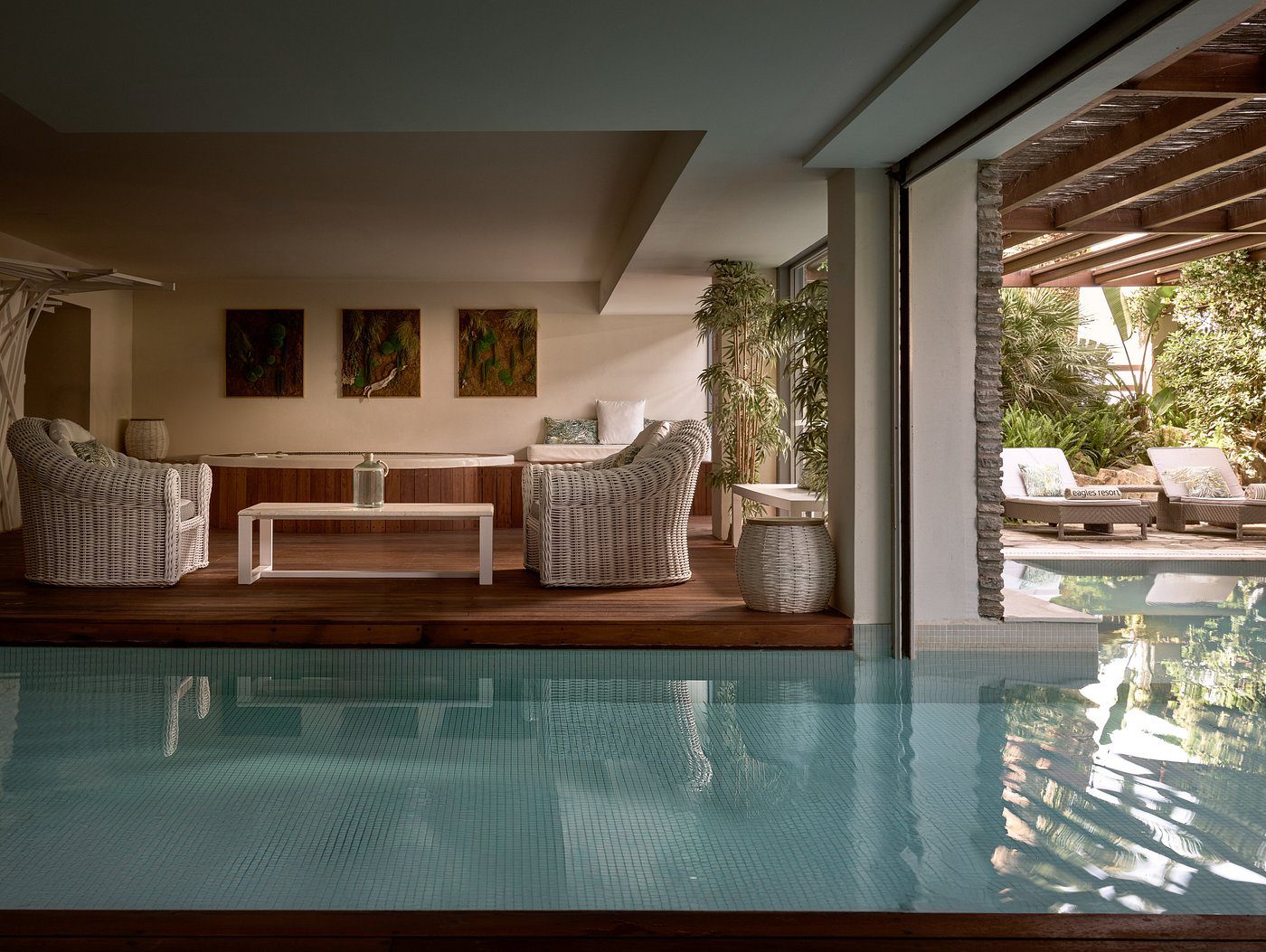 Cozy indoor seating by a serene pool with natural light.