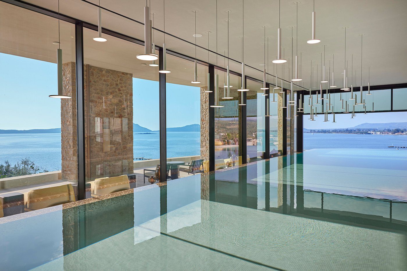 Modern office space with glass walls overlooking a scenic waterfront.