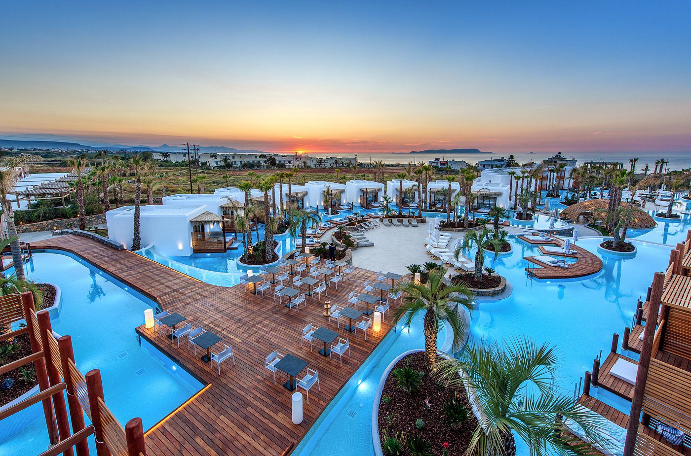 A luxurious pool area with lounge chairs and a sunset view.