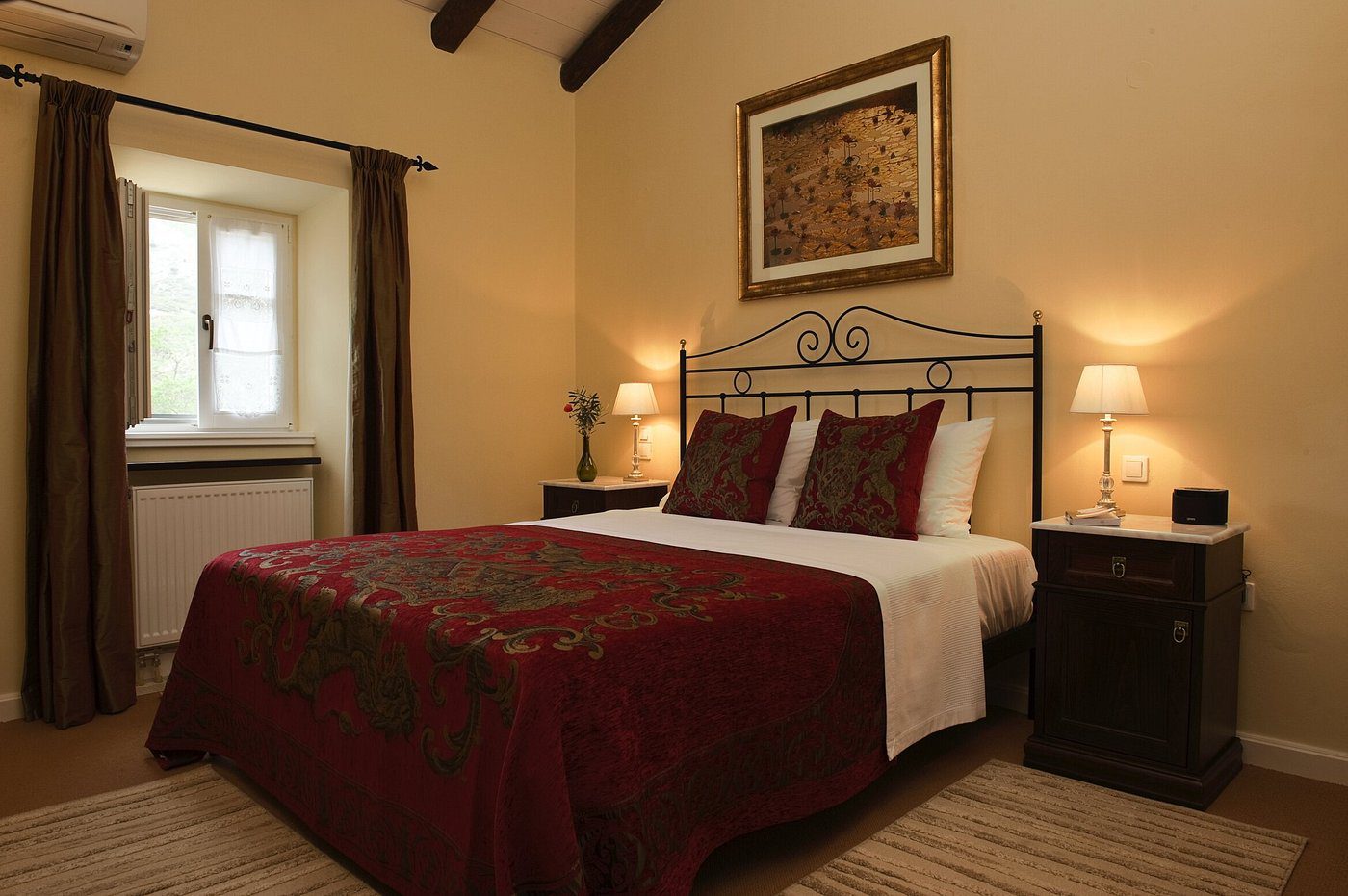 Cozy bedroom with elegant iron bed and warm lighting.