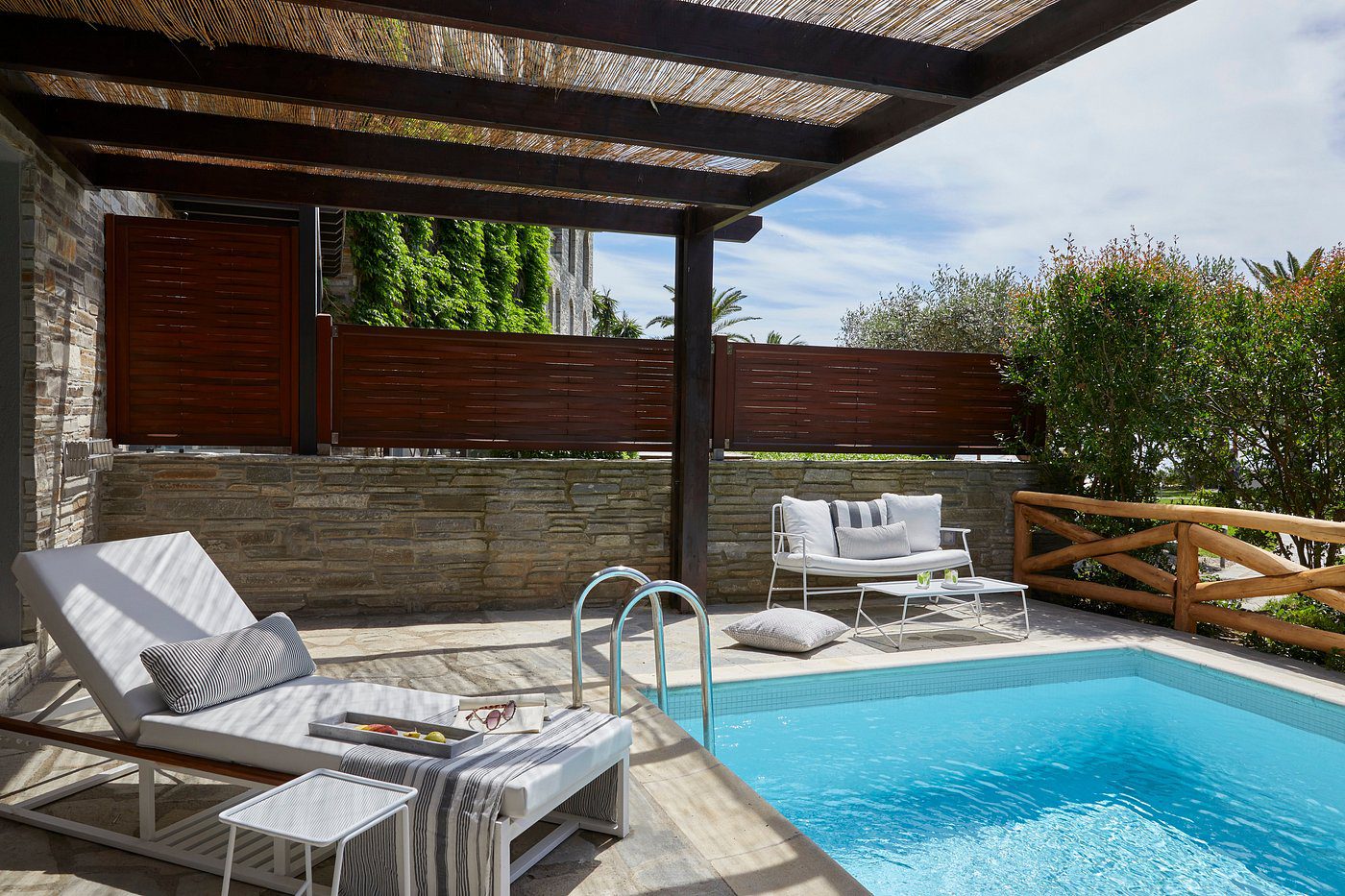 Cozy backyard pool area with lounge chairs and a covered patio.