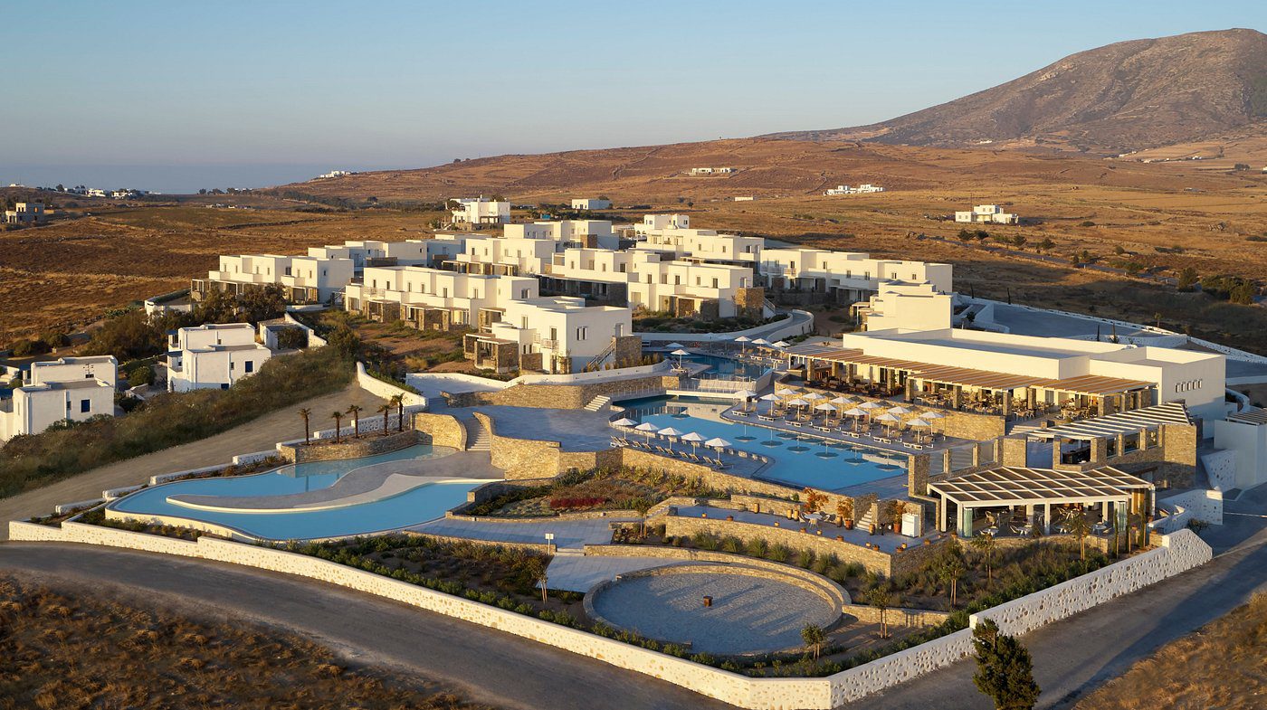 A luxurious resort with pools set against a mountainous backdrop.