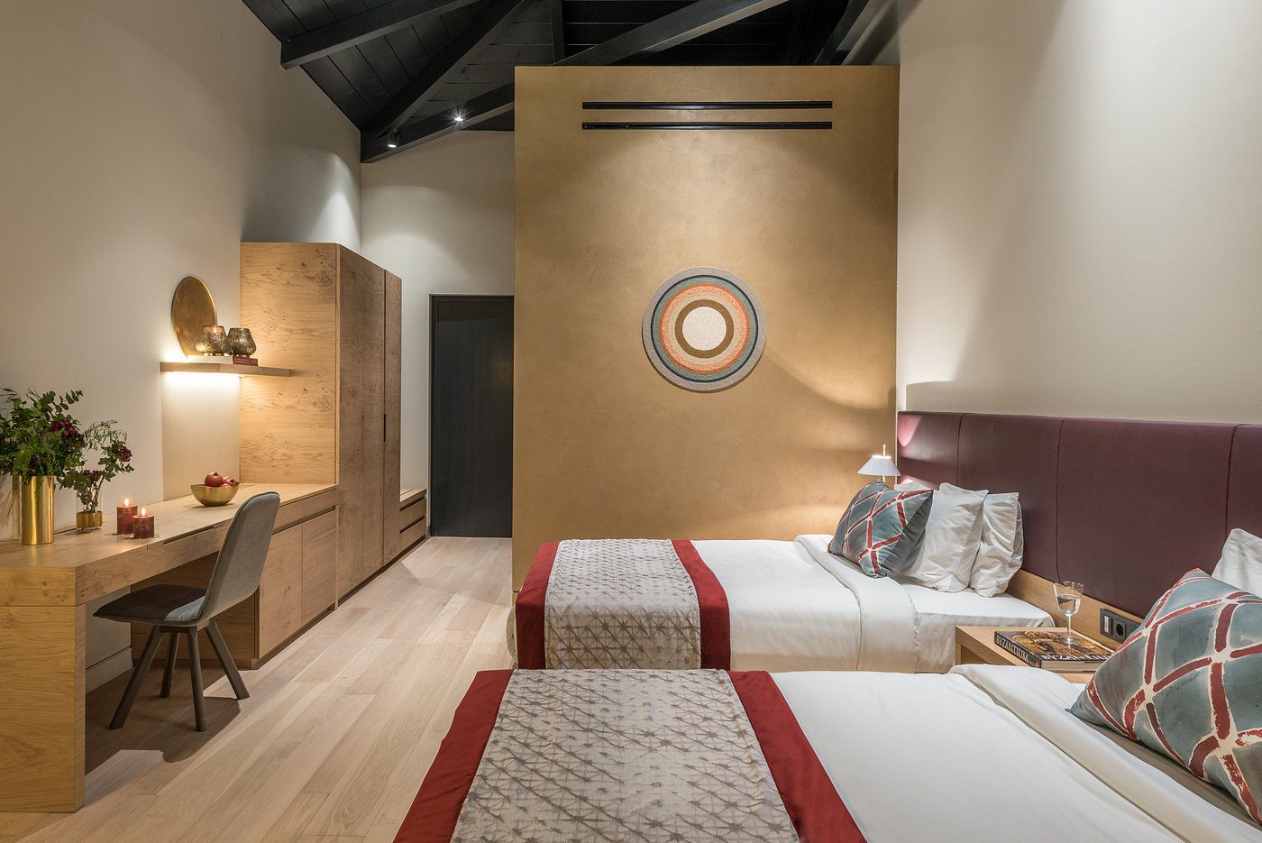 Modern twin bedroom with warm lighting and wooden accents.