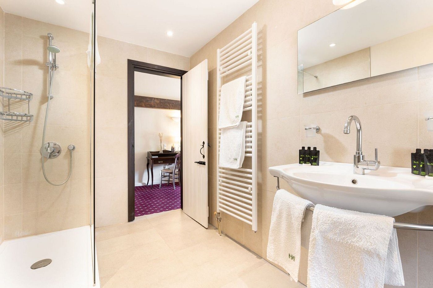 Bright, modern bathroom with white fixtures and open door to carpeted room.