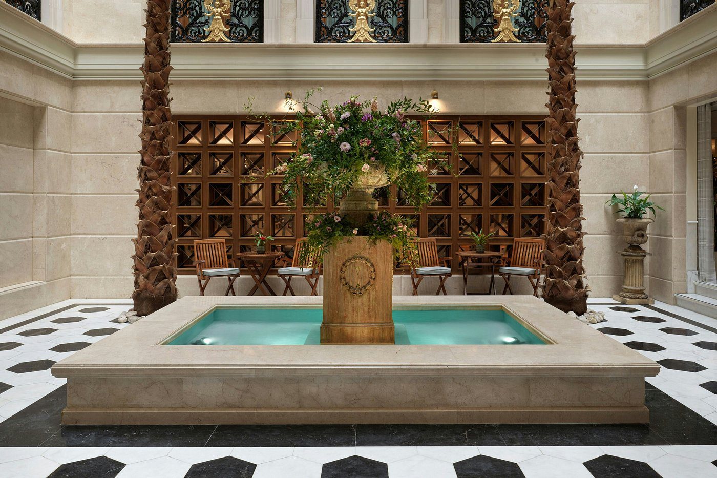 Elegant indoor fountain with lush greenery and a serene pool.