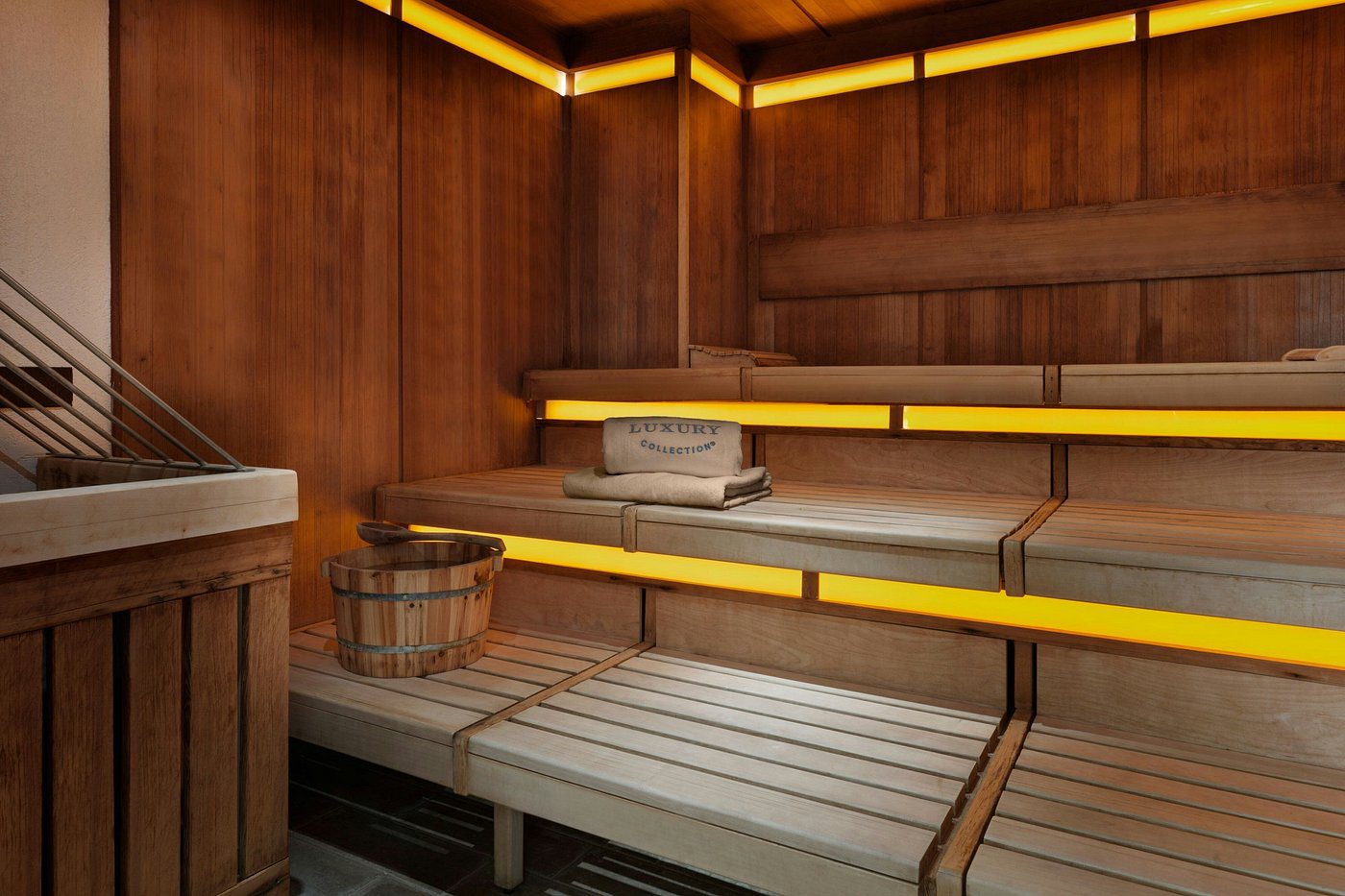 Cozy modern sauna with wooden benches and warm lighting.