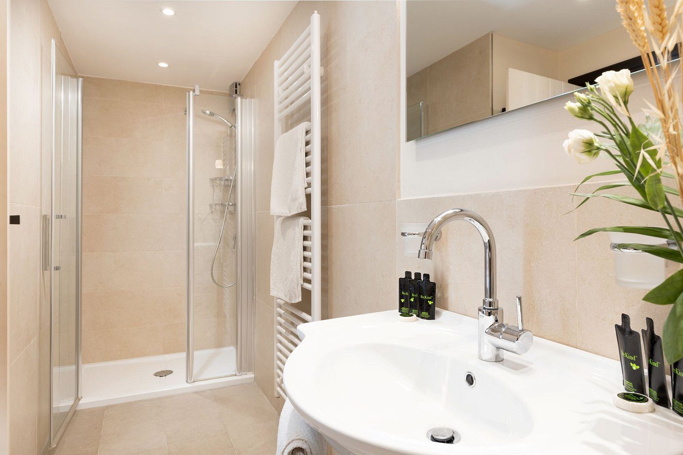 Modern bathroom with white sink and walk-in shower.