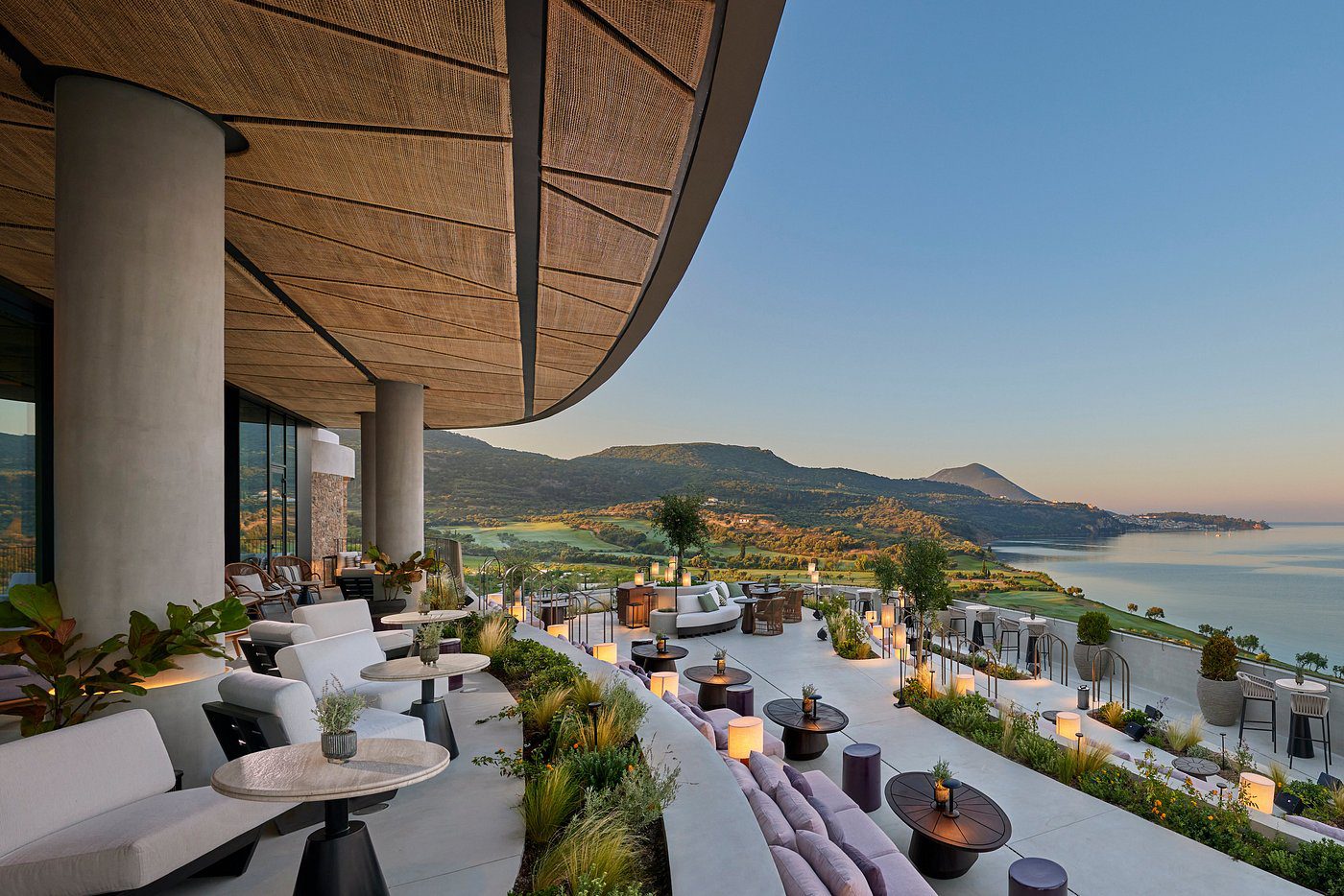 Luxurious outdoor lounge with panoramic mountain views under a clear blue sky.