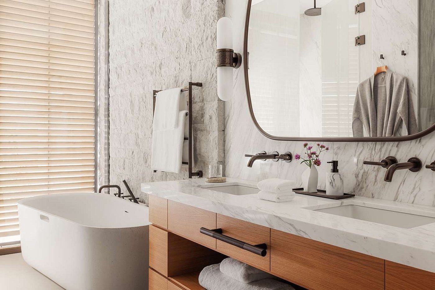 Modern bathroom with wooden vanity and freestanding tub.