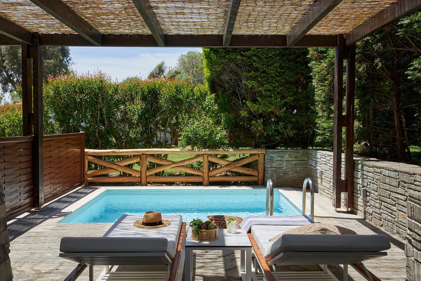 Tranquil poolside view with lounge chairs and greenery.