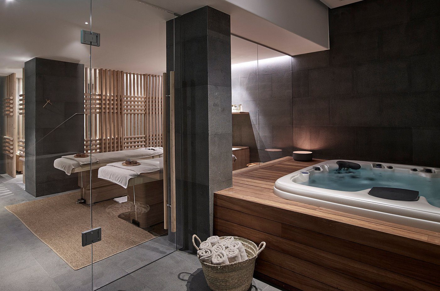 Modern spa room with a jacuzzi and massage beds.