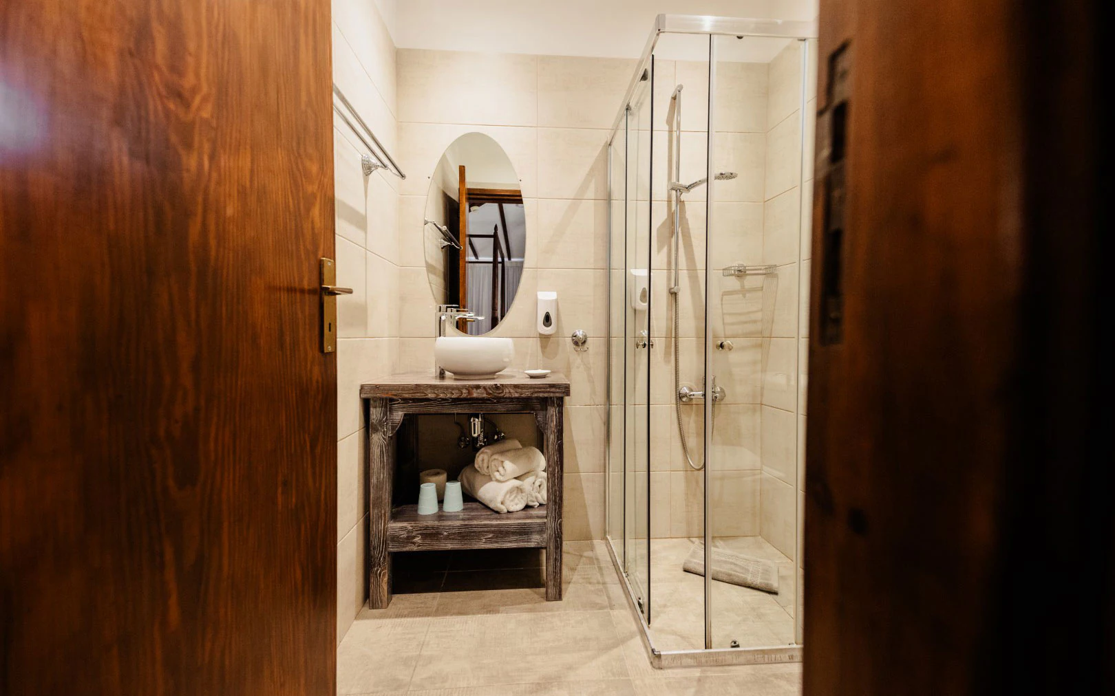 Modern bathroom with glass shower and wooden accents.