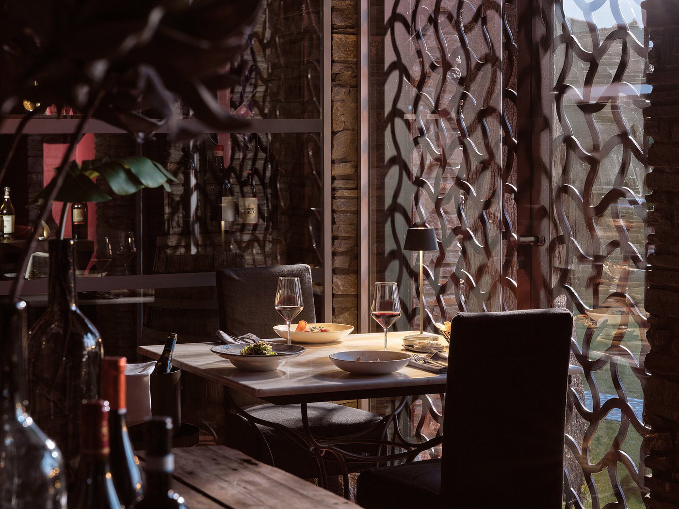 Cozy restaurant table set for dining with wine glasses and plates.
