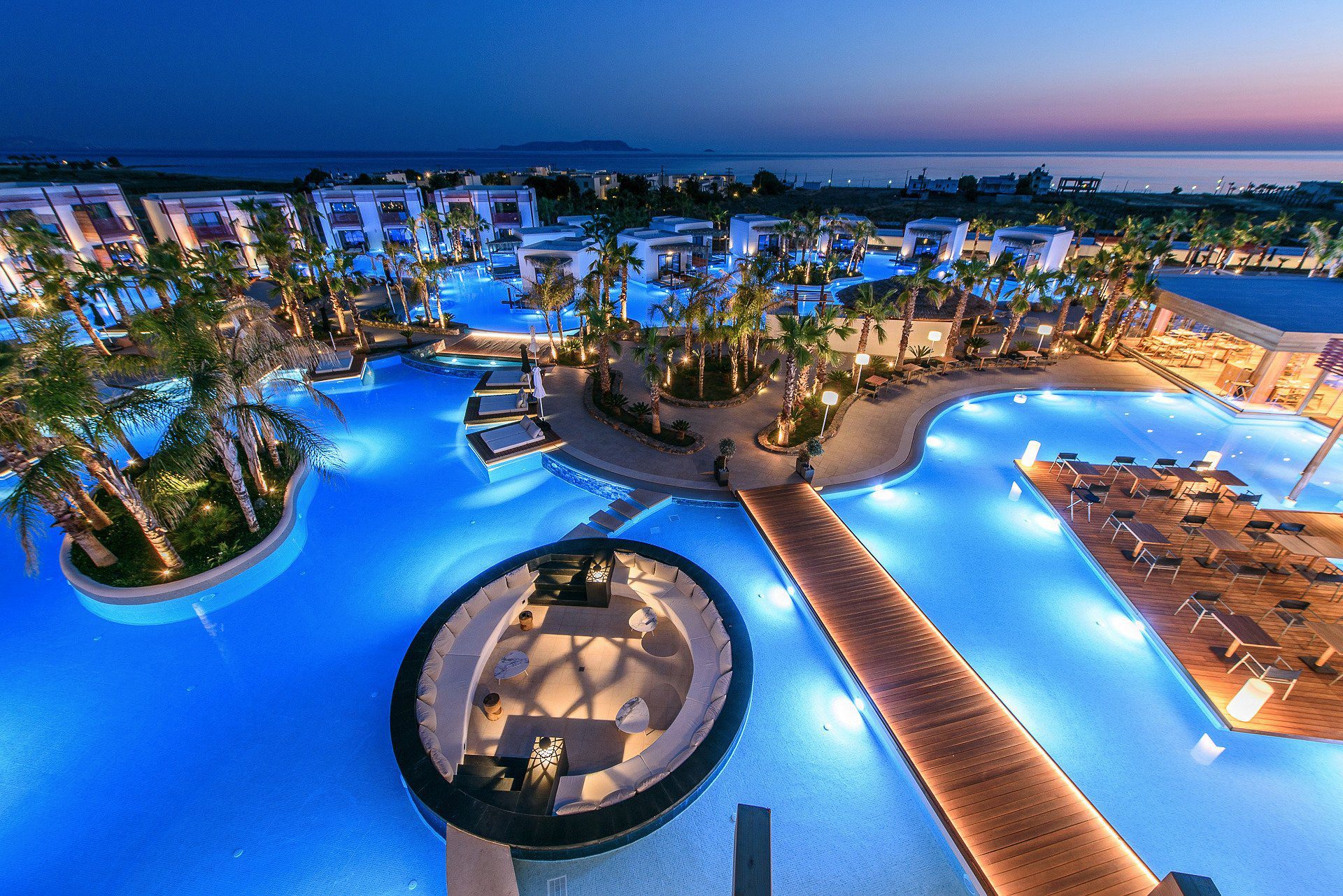 A luxurious resort pool area illuminated at dusk.