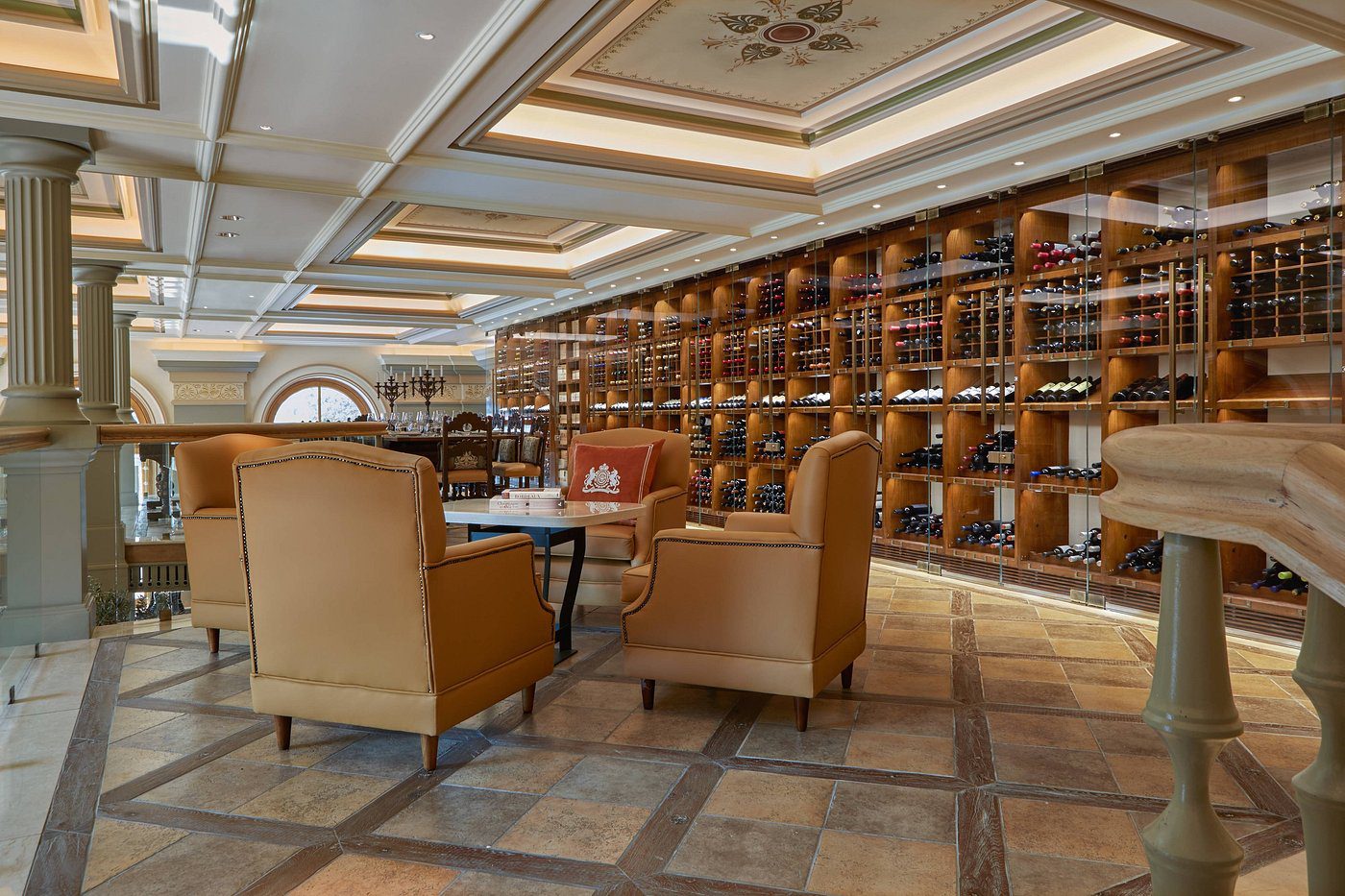 Cozy library seating area with leather armchairs and wooden bookshelves.