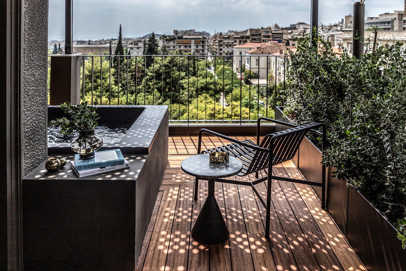 Cozy balcony with a chair, table, and lush green view.